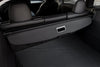 Hoedenplank Tesla Model Y Juniper 2025+ in opgerolde stand achter de achterbank, volledig geïntegreerd in het interieur van de Model Y.
