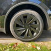 Tesla Model Y Juniper 2025+ met gemonteerde matzwarte Helix 19 inch wieldoppen op een donkergrijze carrosserie