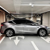 Zijaanzicht van zilveren Tesla Model Y met gemonteerde Zilver Black Helix 19 inch wieldoppen in een moderne parkeergarage
