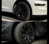 Twee Tesla Model Y voertuigen met zwarte wieldoppen Helix 20 inch gemonteerd, getoond op witte en zwarte uitvoering voor optimaal contrast.